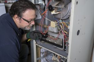 technician-performing-maintenance-on-furnace