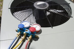 HVAC service and repair gauges connected to an outdoor air conditioning unit during performance testing.